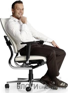 Мужчина сидит на ортопедическом кресле