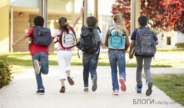 школьники с рюкзаками идут в школу
